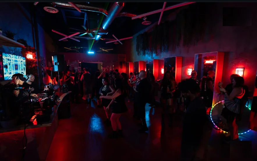 Crowd dancing under red and blue lasers inside Texture Barbershop in Las Vegas during the After Dark all-black affair